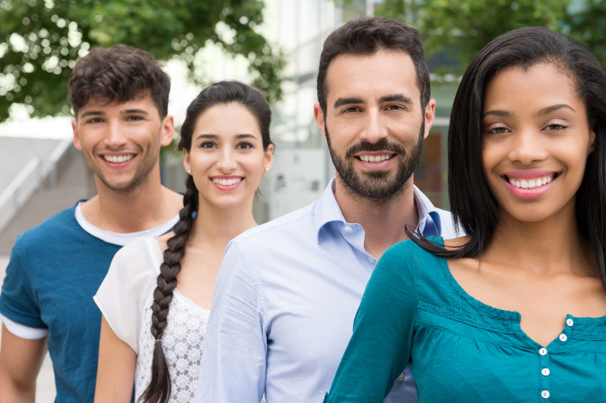 45333927 - closeup shot of young friends standing in a row outdoor. happy group of men and women smiling and looking at camera. happy young friends outside.